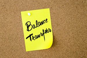 Business Acronym BT as Balance Transfers written on yellow paper note pinned on cork board with white thumbtack copy space available