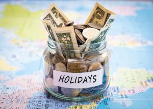 Holidays budget concept. Holidays money savings in a glass jar on world map