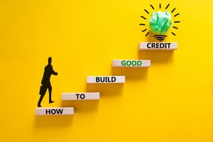 Build good credit symbol. Wooden blocks with words How to build good credit. Beautiful yellow background, copy space. Businessman icon, light bulb. Business and build good credit concept.